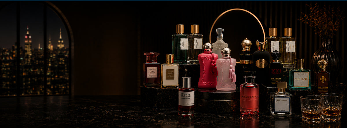 Collection of perfume bottles on a dark surface with a cityscape in the background